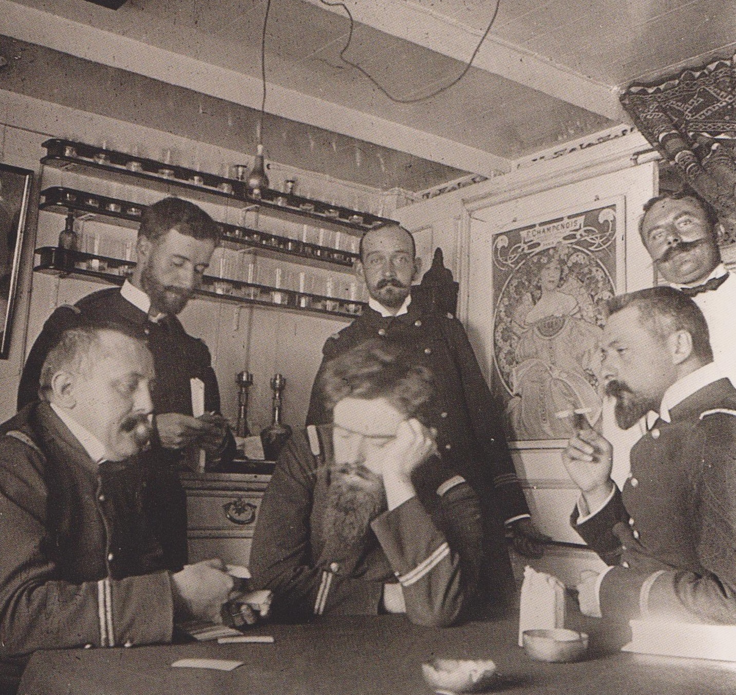 à bord du Vautour, parmi les officiers attablés autour d'une partie de cartes (au-dessus d'eux une affiche de Mucha), on reconnaît à droite l'enseigne de vaisseau Charles Bargone (lécriva, suite 218